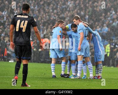 Edin Dzeko (seconda a destra) di Manchester City festeggia con i compagni di squadra dopo aver segnato il secondo goal della sua squadra, mentre Rolando (a sinistra) del FC Porto lascia il campo dopo essere stato inviato Foto Stock