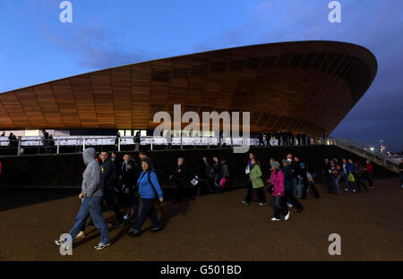 Gli spettatori passano davanti al Velodromo mentre arrivano per la sessione serale durante il secondo giorno della Coppa del mondo di ciclismo su pista UCI al Velodrome nel Parco Olimpico di Londra. Foto Stock