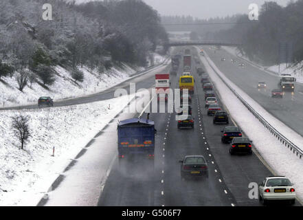 Condizioni di lavoro pericolose per i conducenti dell'autostrada M3 vicino a Basingstoke nell'Hampshire, a seguito di forti nevicate durante la notte. Foto Stock