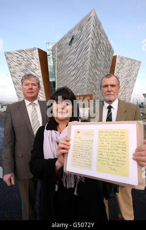 Kate Dornan (al centro), con il fratello Dr John Martin (a destra) e il cugino Dr Denis Martin, con una copia della lettera del loro grande zio Dr John Edward, ouitside il nuovo edificio Titancic firma a Belfast. Foto Stock