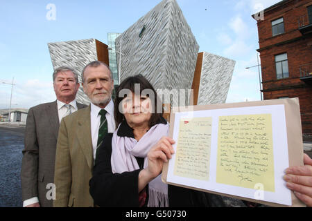 Kate Dornan (a destra), con il fratello Dr John Martin (al centro) e il loro cugino Dr Denis Martin, con una copia della lettera del loro grande zio Dr John Edward, accanto al nuovo edificio Titancic firma a Belfast. Foto Stock