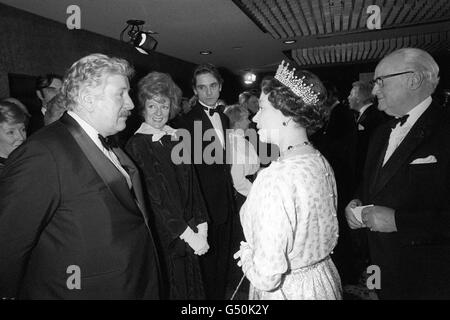 L'attore Peter Ustinov (l) ama la regina guardata dall'attrice Maggie Smith e dall'attore Jeremy Irons (c), stelle del film 'Evil Under the Sun' quando la sua maestà è arrivata per la regia premiere del film a Odeon, Leicester Square, Londra. Foto Stock