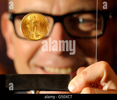 Il CEO dell'ufficio della zecca di Londra Peter Swanston guarda una moneta da 1933 Double Eagle, che sarà esposta alla Goldsmith's Hall di Londra il 3 e 4 marzo 2012. Foto Stock