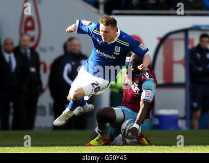 Joe Mason della città di Cardiff (a sinistra) viene inviato in volo sotto il Sfida di West Ham United's Abdoulaye Faye Foto Stock