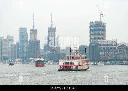 Cina, Shanghai Shanghai alto edificio siti con fiume vecchio steamboat in primo piano Foto Stock