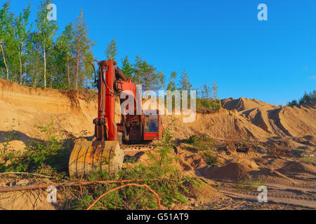 Escavatore lavorando sulle dune di sabbia in cava Foto Stock