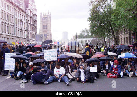 Manifestanti eritrei seduti a Whitehall, poco prima che le scene si trasformino in brutto. La polizia ha chiuso la strada dopo un violento scontro tra etiopi e 300 dimostranti eritrei fuori Downing Street, e circa 150 ufficiali sono intervenuti. * ...come una folla etiope ha colpito pietre ai manifestanti eritrei durante scene violente in cui alcune persone sono rimaste ferite e altre arrestate. Gli eritrei hanno iniziato la loro protesta nel centro di Londra dopo che l'esercito etiope ha intensificato la sua offensiva contro le forze eritree nel Corno d'Africa. Foto Stock