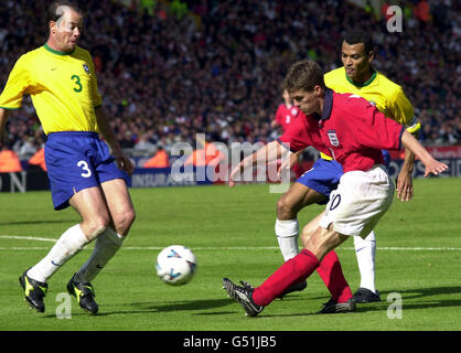 L'inglese Michael Owen (R) prende un colpo sul gol, guardato dal brasiliano Antonio Carlos (L) e Cafu (dietro a destra), durante la loro amichevole partita di calcio internazionale a Wembley. Foto Stock