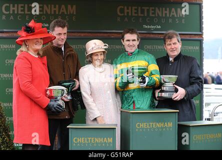 Jockey Tony McCoy (seconda a destra), allenatore Tom Mullins (a sinistra) e proprietario John P McManus (all'estrema destra) festeggiano la vittoria dell'ostacolo Vincent o'Brien County handicap con Alderwood, il giorno della Gold Cup, durante il Cheltenham Festival. Foto Stock