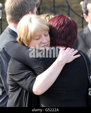 La madre di Christopher McManus Laura (a sinistra) riceve un abbraccio da un amico al suo funerale presso la Madonna del Monte Carmelo e la Chiesa di San Patrizio, Oldham. Foto Stock