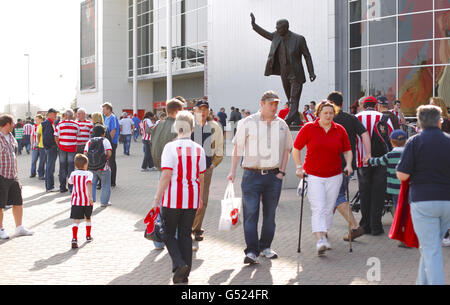 Una statua dell'ex giocatore e manager di Southampton Ted Bates svetta sui tifosi fuori dallo stadio St Mary di Southampton. Foto Stock