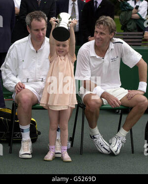 La figlia di John McEnroe, di quattro anni Anna McEnroe, detiene il trofeo di suo padre per aver vinto una partita di beneficenza contro Bjorn Borg (R) a Buckingham Palace durante la sfida NSPCC del Duke of York. Foto Stock