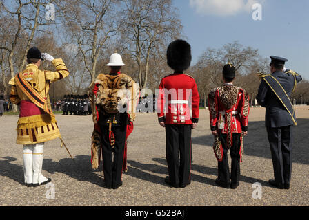 Membri dell'esercito (da sinistra a destra) Senior Drum Major Betts of the Scots Guards, Bugler Lee Kidd of the Royal Marines, Guardsman Andy Caro delle guardie del Coldstream, Lance Corporal Michael strong of the Princess of Wales Royal Regiment, E il garante Terry Gardner della Royal Air Force, salutano la band della Scots Guard mentre si presentano a Wellington Barracks, Londra, nelle loro uniformi cerimoniali a Wellington Barracks, che indosseranno quando prenderanno parte alle celebrazioni del Giubileo dei Diamanti della Regina nel mese di giugno. Foto Stock