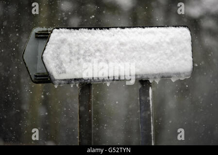 Un cartello stradale coperto di neve nel Brecon Beacons, Galles del sud, in quanto decine di migliaia di casalinghi stanno affrontando un altro giorno senza potere dopo gelate gales e neve ha portato la Gran Bretagna all'inizio dell'estate ad una brusca fine Foto Stock