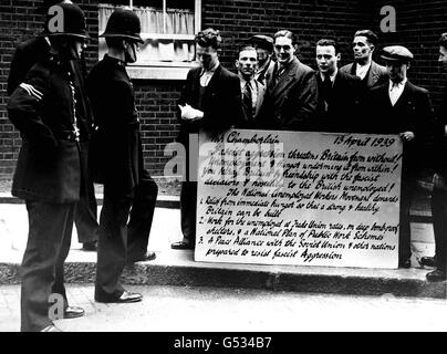 1930 DISOCCUPATI: Un gruppo di uomini del movimento nazionale dei lavoratori disoccupati a Downing Street, Londra, con una 'cartolina di protesta' che elenca varie lamentele e suggerimenti per l'attenzione del primo ministro, Neville Chamberlain. Foto Stock