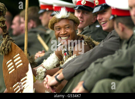 Famiglia Zibaene della squadra di ballo di fanteria sudafricana del 121 di Battaglione Zulu fa una pausa dalle prove dei tatuaggi di Edimburgo per condividere una battuta con la Scotland Band di HM Royal Marines. Il Tattoo il 4/8/00. Foto Stock