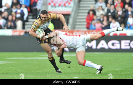 Il Wigan's George Carmont viene affrontato da St Helens Jonny Lomax durante la partita della Stobart Super League a Langtree Park, St Helens. Foto Stock