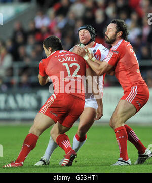 St Helens Jonny Lomax (centro) è affrontato da Widnes's Hep Cahill e Jon Clarke durante la partita di Stobart Super League a Langtree Park, St Helens. Foto Stock