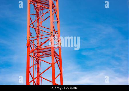 Red industrial gru da cantiere contro il cielo blu Foto Stock