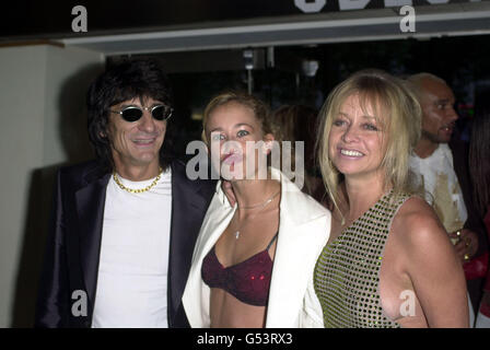 Rolling Stones chitarrista Ronnie Wood con sua moglie Jo (a destra) e la figlia Leah, che tira un volto, arrivando per la prima del film Snatch, all'Odeon Leicester Square, a Londra. Foto Stock