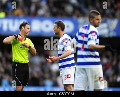 Il Queens Park Rangers' Clint Hill (centro) parla con l'arbitro della partita Mark Clattenburg (a sinistra) dopo il suo compagno di squadra Adel Taarabt (a destra) è inviato fuori Foto Stock