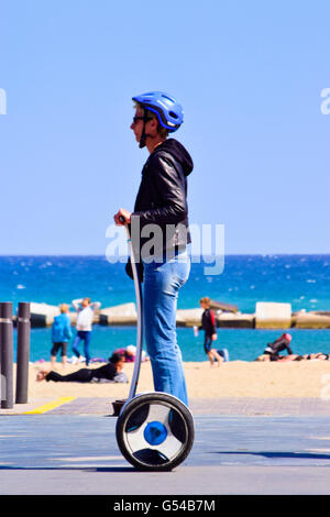 Uomo con casco equitazione Segway vicino alla spiaggia. Barcellona, in Catalogna, Spagna. Foto Stock