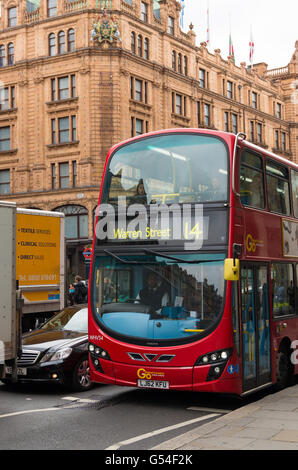 Londra - 19 ottobre 2015: il famoso bus rosso a due piani nella parte anteriore del negozio Harrods nel quartiere di Knightbridge Foto Stock