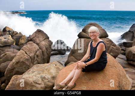 Sri Lanka Galle Provincia, Unawatuna tourist sulla scogliera rocciosa con onde che si infrangono in Foto Stock