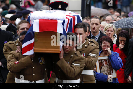 Lisa Billing porta dietro la sua bara una fotografia di suo figlio, il privato Daniel Wade, quando arriva per i suoi funerali alla chiesa di St Elphin, Warrington. Foto Stock