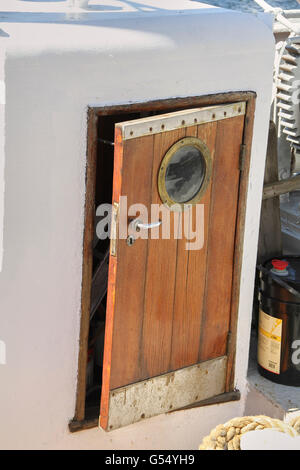 Vecchio brown porta di legno sulla nave con una finestra rotonda Foto Stock