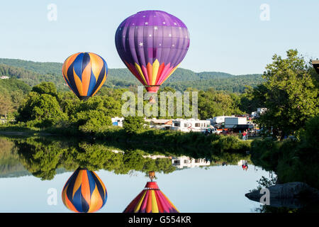 Mongolfiera di decollare sopra fiume durante Quechee mongolfiere festival con la gente nel cestello. Foto Stock