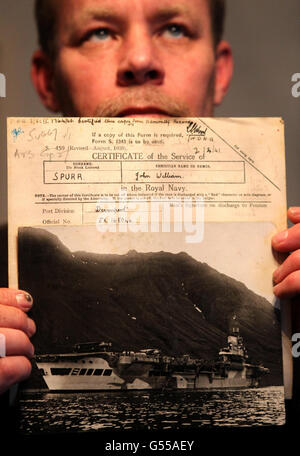 Jason Spurr con una foto di HMS vittorioso e il record marino di suo nonno John Spurr, Alva. Foto Stock