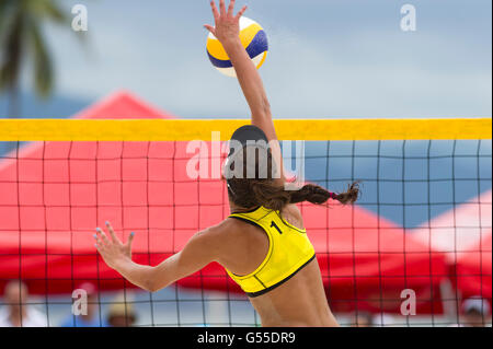 Giocatore di volleyball è un atleta femminile di pallavolo player che si elevano fino al net a martellare la sfera verso il basso. Foto Stock