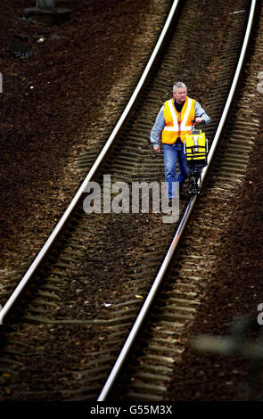 Un ingegnere ferroviario controlla il tracciato della linea principale della costa occidentale vicino a Law in Lanarkshire, dopo che la linea tra Gretna sul confine scozzese e Law Junction, a sud di Glasgow, è stata chiusa per controlli di sicurezza. Gerald Corbett, direttore generale della ferrovia. *... i passeggeri avvertiti dovrebbero aspettarsi una settimana estremamente difficile. Foto Stock