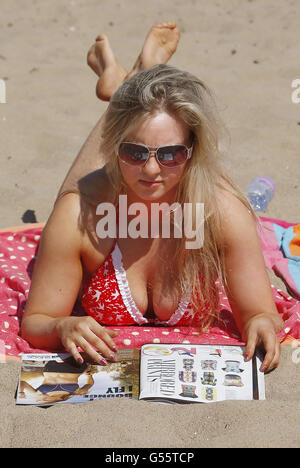 Laura Henderson gode del clima caldo sulla spiaggia di Portobello, vicino a Edimburgo, in Scozia. Foto Stock