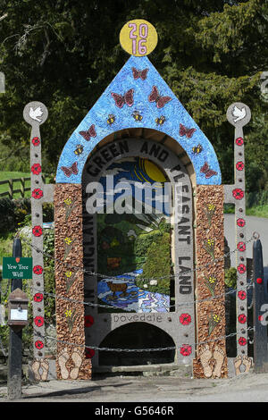 Una folla di orologi come membri della chiesa locale a benedire uno dei sei vestito colorato di pozzi nel Derbyshire village di tissington. Foto Stock