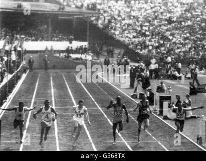 Keith Gardner (estrema destra) della Giamaica si tuffa al nastro per vincere la finale degli uomini di 100 yarde in un tempo record di 9.79. Tom Robinson delle Bahamas (secondo da sinistra) è arrivato secondo con Mike Agostini del Canada (all'estrema sinistra) che arriva terzo. Nella foto sono anche Peter Radford d'Inghilterra (13), Jimmy Omagbemi della Nigeria (32) e Gordon Day (63) del Sudafrica. Foto Stock