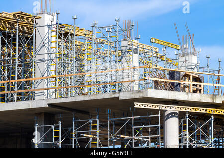 Incompleta e moderno edificio in costruzione con i ponteggi dettaglio Foto Stock