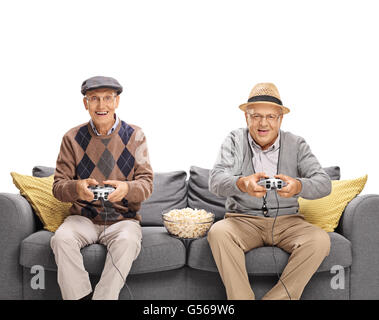 Due anziani gioiosa la riproduzione di video giochi seduto su un divano grigio isolato su sfondo bianco Foto Stock