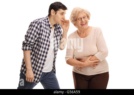 Giovane ragazzo sussurra qualcosa di sua nonna isolata su sfondo bianco Foto Stock