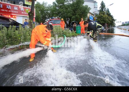 Huzhou, cinese della Provincia di Zhejiang. Xx Giugno, 2016. I vigili del fuoco di acque di scarico su una strada di Huzhou, est della Cina di Provincia dello Zhejiang, 20 giugno 2016. Piogge torrenziali che hanno colpito la città di domenica sera, causando waterlogging nel centro cittadino di aree. Le precipitazioni giornaliere ha stabilito un nuovo record con 227.2 millimetri da 6 p.m. Lunedì. Credito: Zhang Jian/Xinhua/Alamy Live News Foto Stock