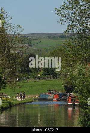 Una barca si fa strada lungo il canale di Leeds e Liverpool a Five Rise Locks, Bingley, West Yorkshire, mentre il caldo tempo continua in tutto il Regno Unito. Foto Stock