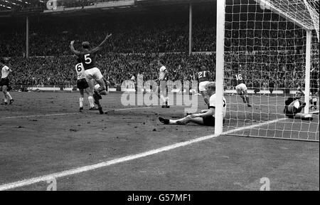 La scena dopo il punteggio del secondo gol dell'Inghilterra, segnato da Martin Peters (No16), nella finale della Coppa del mondo contro la Germania occidentale allo stadio di Wembley. Hans Tilkowski, il portiere tedesco, è visto in bocca. Jackie Charlton (No5) getta le braccia in delizia. No21 è Roger Hunt, No6 è Wolfgang Weber. Foto Stock