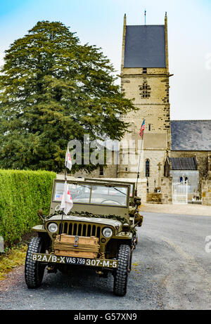 Angoville-au-Pianura, Carentan, Normandia, Francia - una Willys MB carrello ¼ ton Jeep 4x4 montato in ambulanza montare al di fuori della chiesa Foto Stock