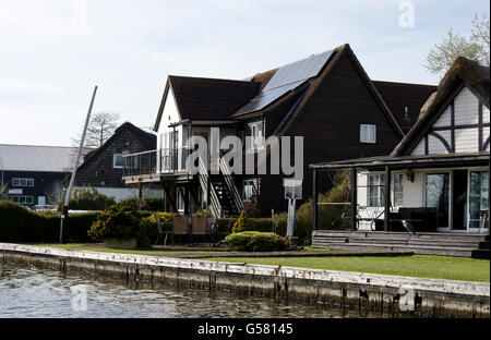 Riverside case vicino Horning sul fiume Bure in il Parco Nazionale Broads del Norfolk, Inghilterra. Foto Stock