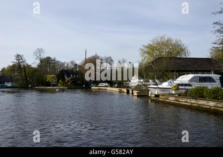 Bellissimo tratto del fiume Bure vicino Horning su il Parco Nazionale Broads del Norfolk, Inghilterra, foderato con waterside case. Foto Stock