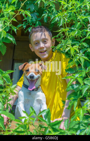 Ragazzo sorridente con il cane su treehouse. L'estate! Foto Stock