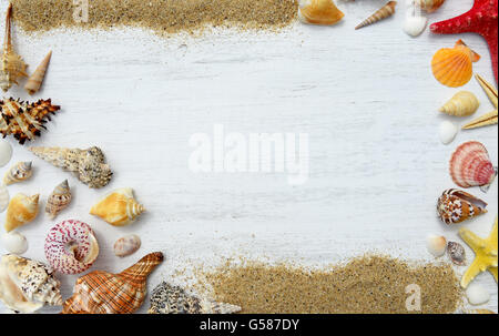 La sabbia, conchiglie e stelle marine su uno sfondo di legno Foto Stock