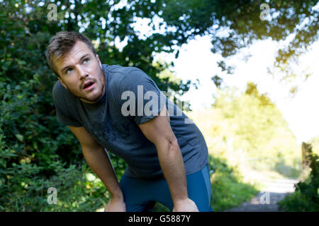 Giovane uomo avente una veloce pausa dal suo run Foto Stock