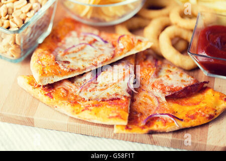 Close up di pizza e altri snack sul tavolo di legno Foto Stock